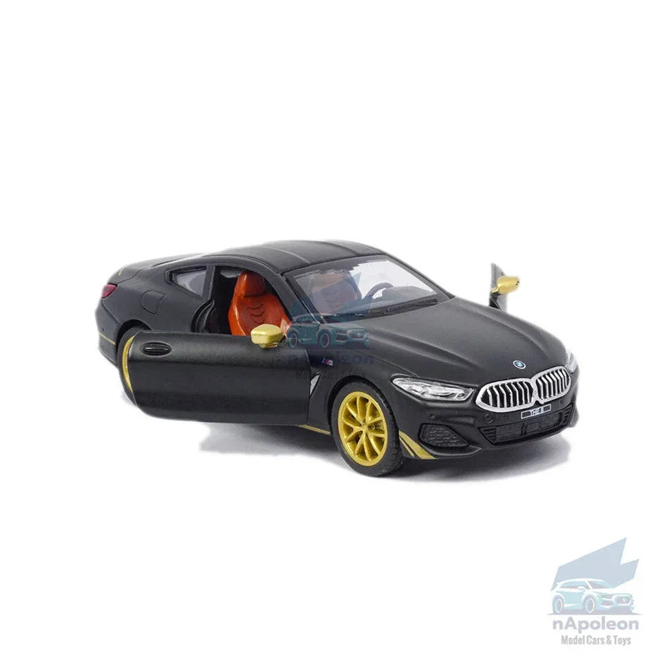 BMW M850i matte black diecast model car with gold wheels, open doors, and orange seats