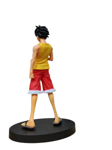 Figurine of a character in yellow tank top and red shorts on a white background