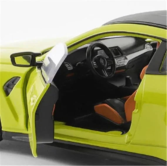 Miniature yellow BMW M4 G82 coupe model car with open door and detailed interior