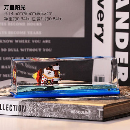 Miniature pirate ship in glass case on books, decorative desk accessory, modern style