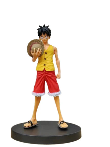 Figurine of a character in a yellow shirt and red shorts holding a hat on a white background