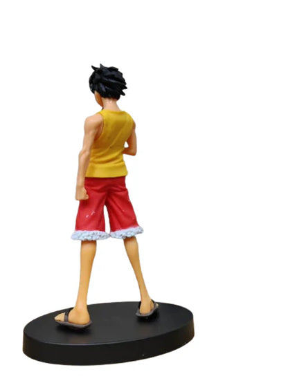 Figurine of a character in yellow tank top and red shorts on a white background